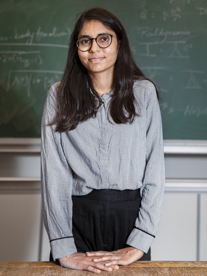 Portrait photo de Tamanna Jain posant devant un tableau noir.
