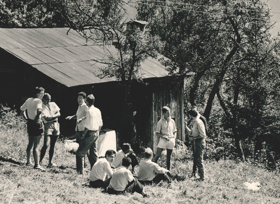 Première école d'été des Houches en 195. Photo noir et blanc de chercheurs au repos devant un chalet en bois