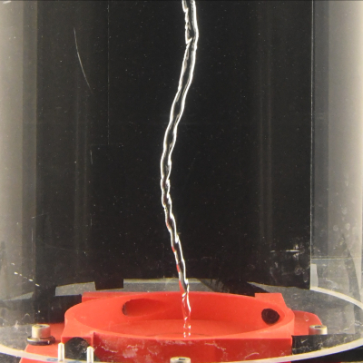 Une cuve cylindrique transparente est remplie d’eau et contient en son centre un fin cœur d’air, formant un vortex de vidange d’environ 40cm de long pour seulement quelques millimètres d‘épaisseur.