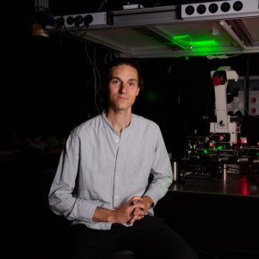 Photo portrait de Nathan Ronceray deant un banc optique
